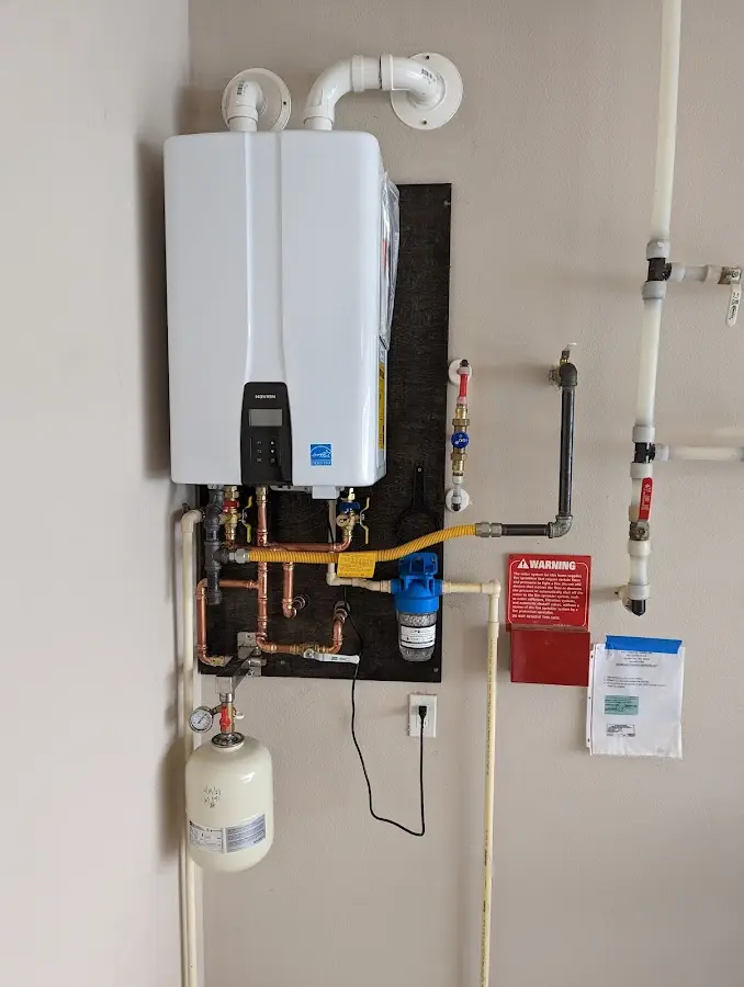 Professional plumber installing copper piping in a Le Mars home